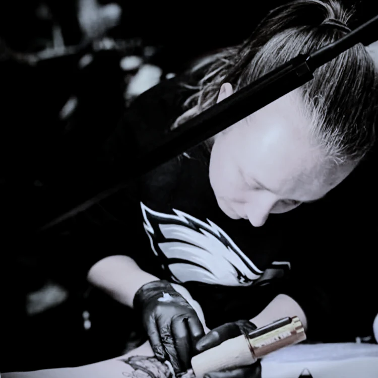 Tattoo artist creating a detailed forearm tattoo inside Jinked tattoo studio in Porthcawl.